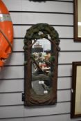 A ceramic framed wall mirror with frame in the style of a forest.