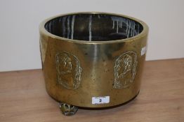 A Japanese Meiji period brass planter, having moulded Geisha design to sides, sat aloft spherical