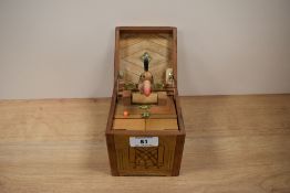 A vintage mechanical musical pop up bird in a box cigarette dispenser