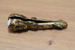 A pair of cast brass nut crackers in the form of a clown.