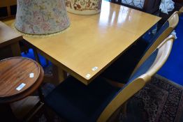 A modern beech effect extending dining table and six chairs