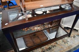 A modern hardwood console table having glass top and mirror base