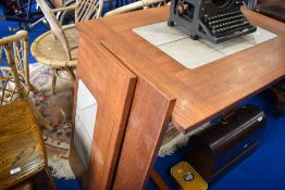 A vintage teak extending dining table with tiles inset