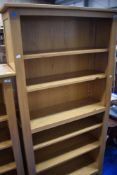 A modern golden oak tall bookcase