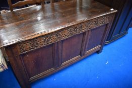 A period oak kist having carved frieze and three panels to front, width approx. 115cm