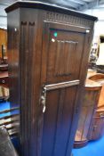 A traditional dark oak hall robe with linen fold door