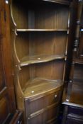 A modern mid stained Ercol corner shelf with cupboard to lower part
