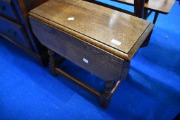 A reproduction oak drop leaf low occasional table