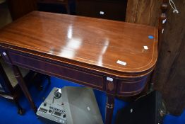 An Edwardian mahogany fold over card table (damaged hinges)