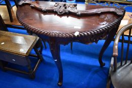 A reproduction hardwood demilune hall table