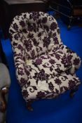 A 19th Century easy chair having walnut knurl frame and later upholstery