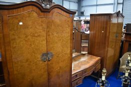 An early to mid 20th Century walnut bedroom suite comprising two wardrobes and dressing table