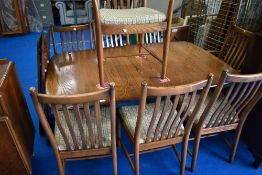 A modern Ercol dining room table, extending , with three additional leaves and eight (six plus