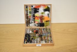 A wooden box containing approximately 600 hand tied flys and Lures doubles and winged trout