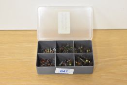 A pocket box containing approximately 70 fishing flies. Gold beaded montanas and Large midge
