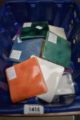A carton containing a selection of vintage tiles in assorted colours.
