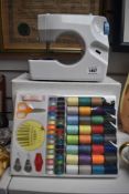 A small/childs 6v sewing machine with threads etc.