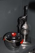 A stainless steel mechanical juicer and a mid-20th century thermos ice bucket