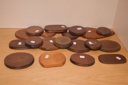 A collection of eighteen mahogany plinths, of circular and shaped outline, the majority with baize