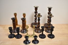 An assorted collection of candlesticks, turned wood candlesticks and ebonised candlesticks