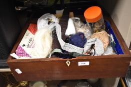 A mahogany box filled with as selection of mixed modern and vintage haberdashery.