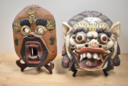 Two hand carved wall masks, of Balinese or Chinese design