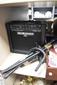 A Behringer portable amplifier and a guitar stand.