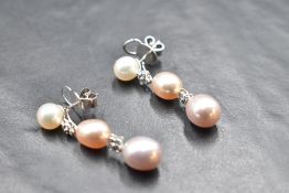 A pair of 18ct white gold stud earrings having cultured pearl stud with four stone diamond fixed