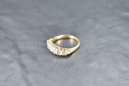 A five stone graduated diamond ring, total approx 1ct, having diamond chip spacers (3 missing) in