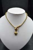 A Victorian yellow metal serpent/snake necklace having a ruby set moulded head with suspended