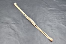 A yellow metal fixed double rope chain bracelet stamped 14K having a ten diamond panel, total approx