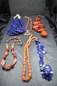 A selection of strings of beads including lapis lazuli, carnelian, Baltic amber style etc