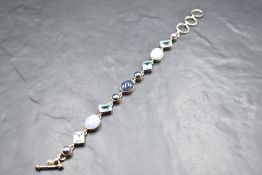 A white metal bracelet, presumed silver having blue topaz, agate, lapis lazuli and split pearl