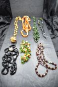 A small selection of strings of beads including Amber style, mourning, 1950's moulded glass etc