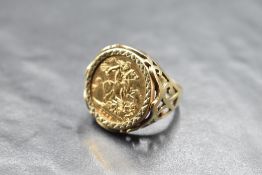 A Queen Elizabeth II sovereign coin ring, IRB 2003, held within a geometrically cut bezel mount