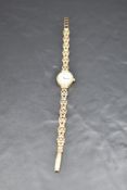 A lady's 9ct gold wrist watch by Rotary having baton numeral dial to oval face in gold case on a 9ct