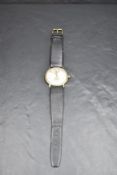 A gent's 1970's 9ct gold manual wrist watch by Garrard having Arabic numeral dial in a gold case