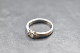 An artisan style diamond trilogy ring having a central diamond in collared mount flanked by two