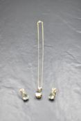 A 9ct gold pendant and matching stud earrings, all having large facetted pear cut pale green stones,