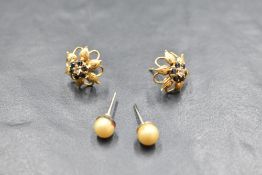 A pair of 18ct gold diamond and sapphire flower head form cluster earrings, the central diamonds