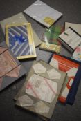 An assortment of vintage table linen, predominantly in original packaging, including table cloths