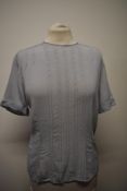 A 1940s/50s blouse in a pale blue, having buttons fastening to reverse and ladder work to front,