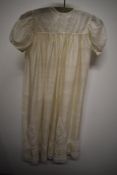 An antique gossamer fine silk childs gown, having embroidery to bodice and hem, panels of lace to