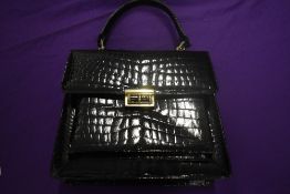A vintage black patent handbag.
