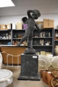A chalkware putti statue on stand, measuring 65cm tall
