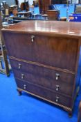 An early 20th Century tallboy by Waring & Gillow having drop flap section over three drawers