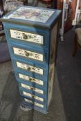 A modern painted narrow chest of storage drawers