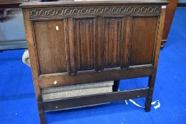 An early 20th Century oak bed head, having linen fold decoration