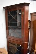A late 19th/early 20th Century mahogany double height corner display cabinet