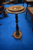 A 19th Century torchere having tulip column and paw feet